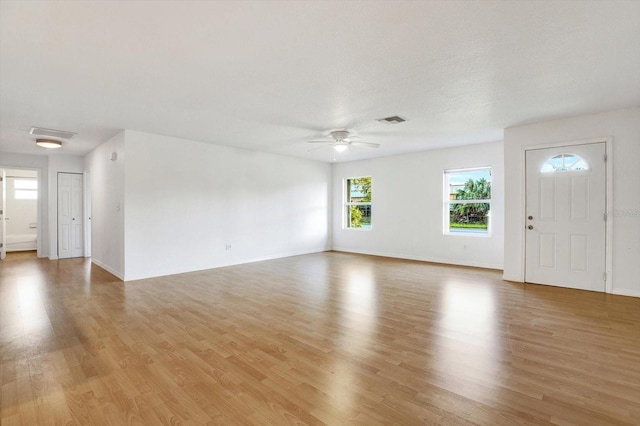 unfurnished living room featuring ceiling fan and light hardwood / wood-style floors