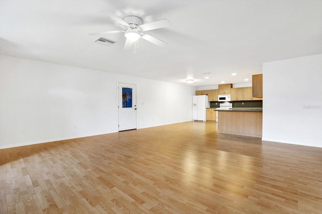 unfurnished living room featuring ceiling fan and light hardwood / wood-style floors