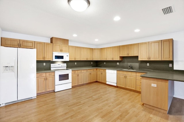 kitchen featuring white appliances, sink, decorative backsplash, and light hardwood / wood-style floors