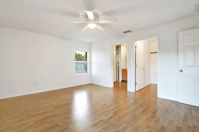 interior space featuring light wood-type flooring, a walk in closet, and ceiling fan