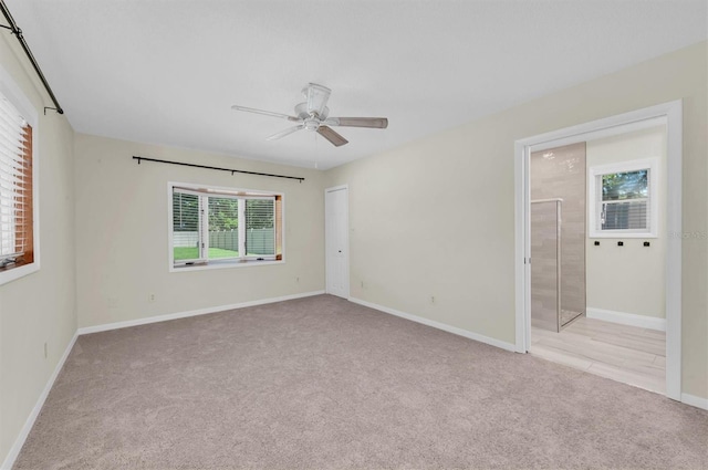 spare room featuring light carpet and ceiling fan