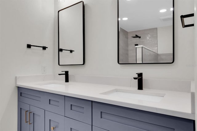 bathroom featuring a tile shower and vanity