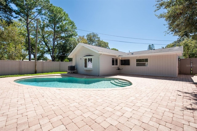 view of pool with cooling unit and a patio area