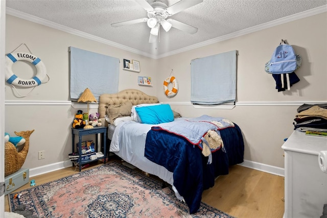 bedroom with wood-type flooring, ornamental molding, a textured ceiling, and ceiling fan