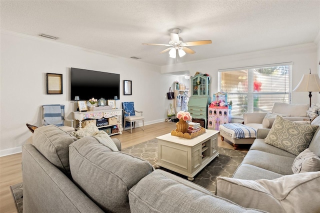 living room featuring hardwood / wood-style floors, ceiling fan, a textured ceiling, and ornamental molding