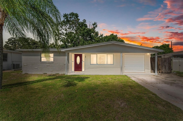 single story home featuring a yard and a garage