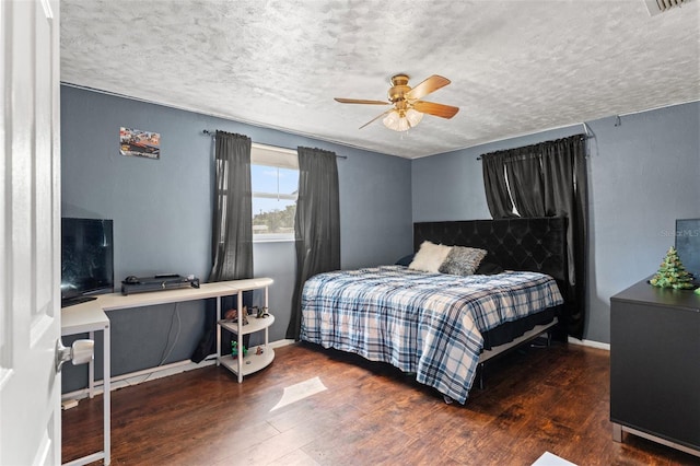 bedroom with ceiling fan, dark hardwood / wood-style floors, and a textured ceiling