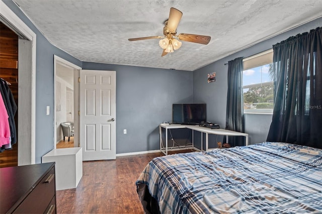 bedroom with dark wood-type flooring, a textured ceiling, and ceiling fan