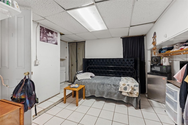 tiled bedroom with stainless steel refrigerator and a drop ceiling