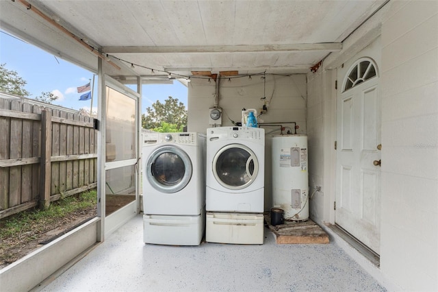 clothes washing area featuring electric water heater and washer and dryer