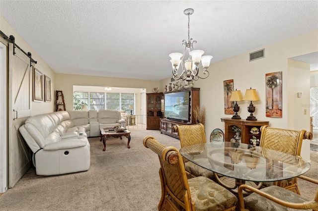 dining area with carpet, a barn door, an inviting chandelier, and a textured ceiling