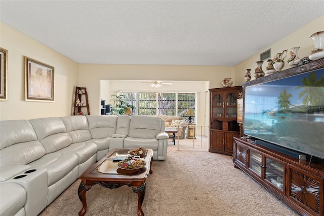 carpeted living room featuring ceiling fan and a textured ceiling