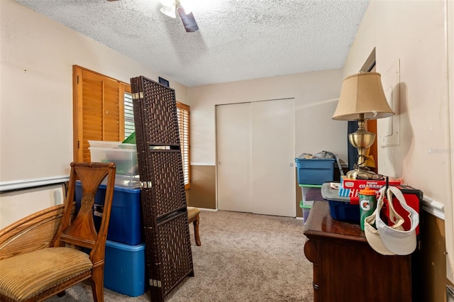 carpeted bedroom featuring a textured ceiling and ceiling fan