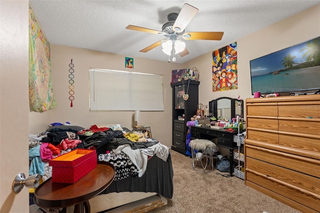 carpeted bedroom featuring ceiling fan and a textured ceiling