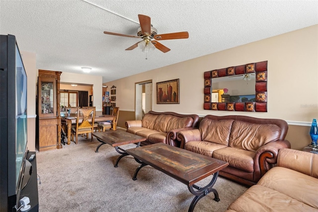 carpeted living room with ceiling fan and a textured ceiling