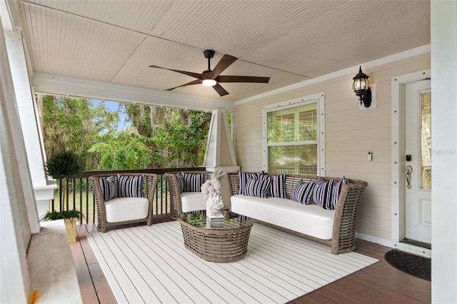 wooden deck with an outdoor living space, ceiling fan, and covered porch