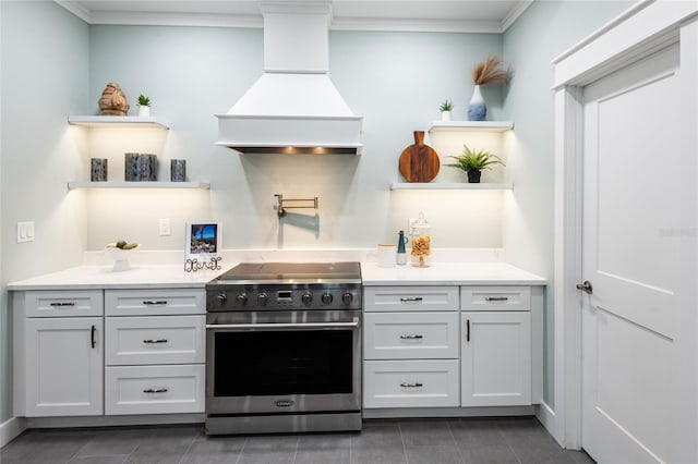 kitchen featuring open shelves, light countertops, custom exhaust hood, and high end range