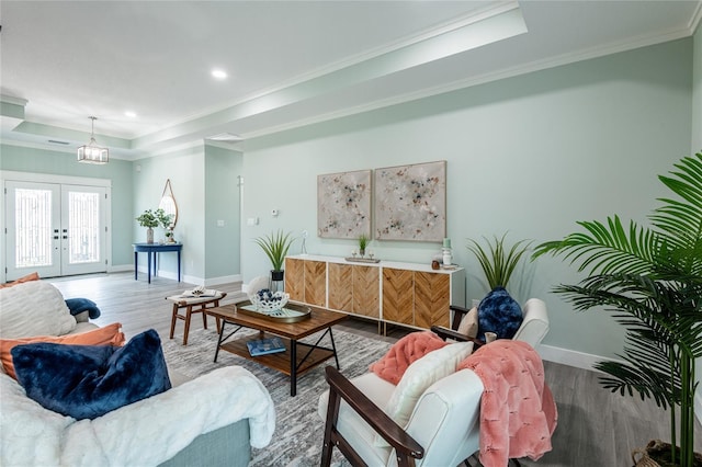 living room featuring wood finished floors, french doors, a raised ceiling, and baseboards