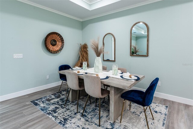 dining room with hardwood / wood-style floors and ornamental molding