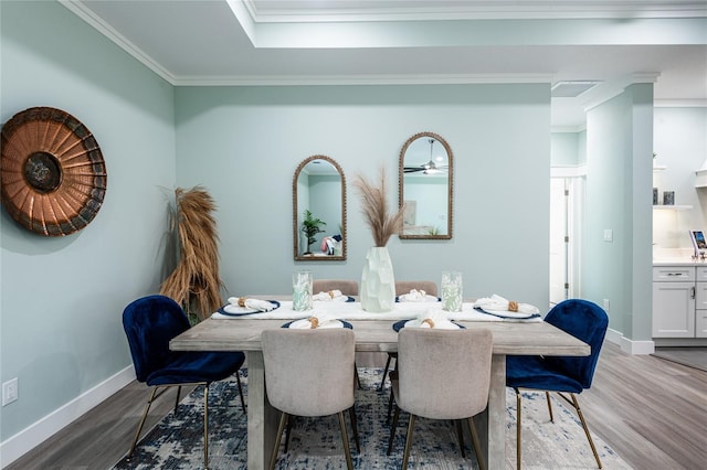 dining room featuring baseboards, ornamental molding, and wood finished floors