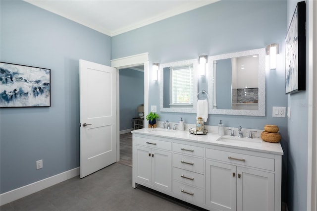 full bath featuring double vanity, crown molding, baseboards, and a sink