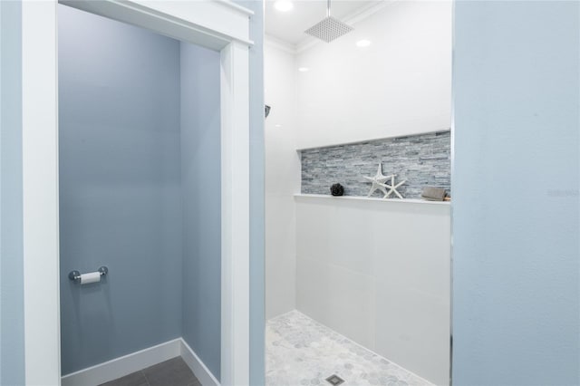 full bath with baseboards, ornamental molding, a tile shower, and tile patterned floors