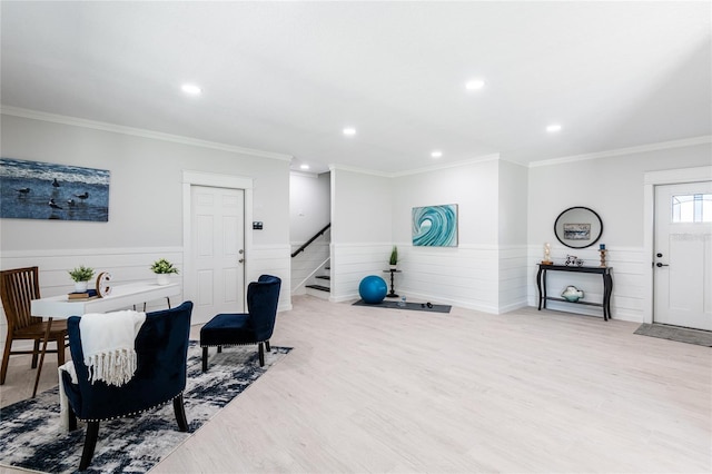 workout area featuring crown molding and light hardwood / wood-style floors