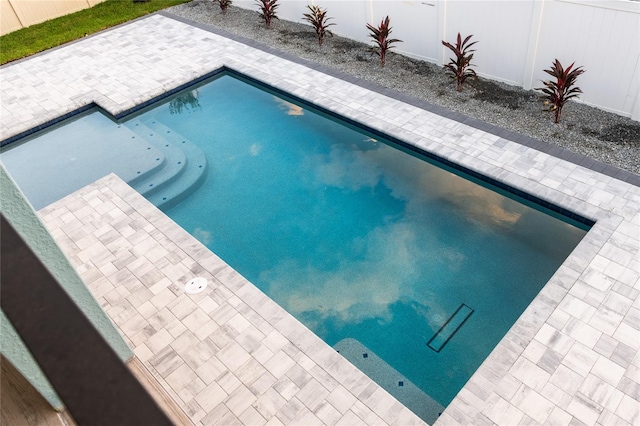 pool with a patio and fence