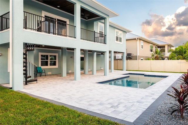 back of house with a fenced in pool, ceiling fan, and a patio