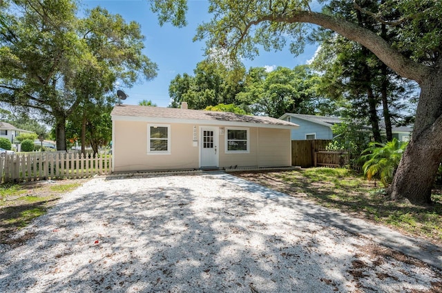 view of front facade featuring gravel driveway and fence