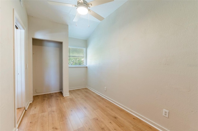 unfurnished bedroom featuring baseboards, lofted ceiling, light wood-style floors, a closet, and a ceiling fan