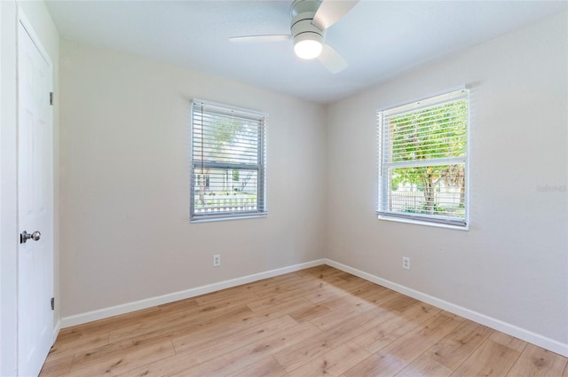 empty room with baseboards, light wood-style floors, and a ceiling fan