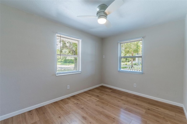 unfurnished room with a wealth of natural light, baseboards, and light wood-style floors