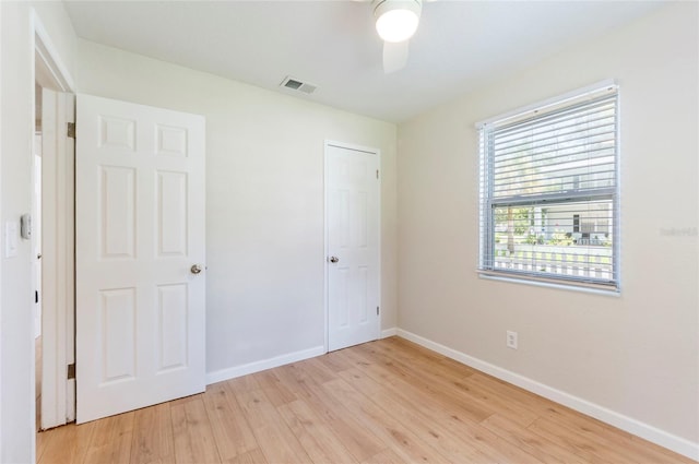 unfurnished bedroom featuring visible vents, baseboards, light wood-style floors, and a ceiling fan