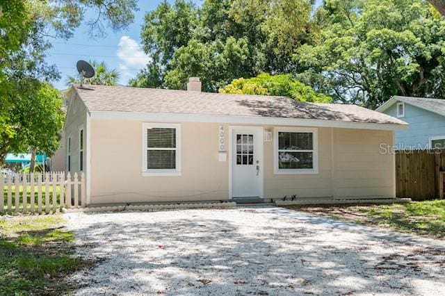 single story home featuring fence and a chimney