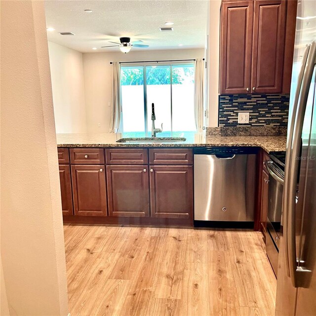 kitchen with backsplash, dishwasher, light hardwood / wood-style flooring, sink, and ceiling fan