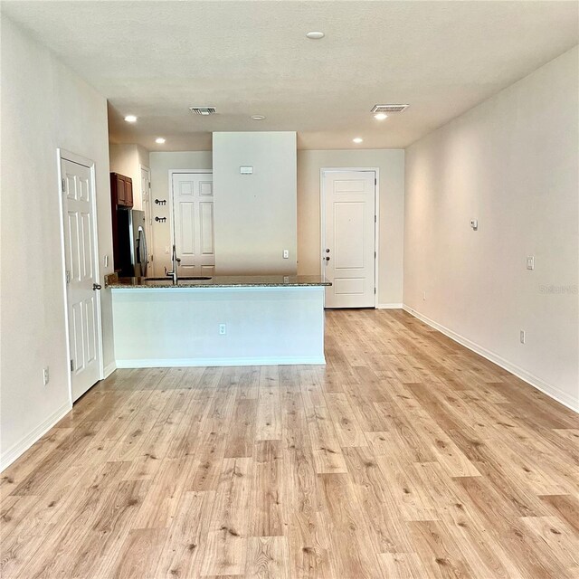 kitchen featuring light hardwood / wood-style floors, stainless steel refrigerator with ice dispenser, and sink