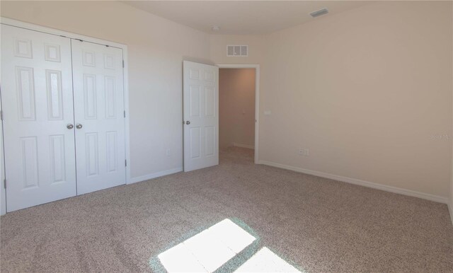 unfurnished bedroom with carpet floors and a closet