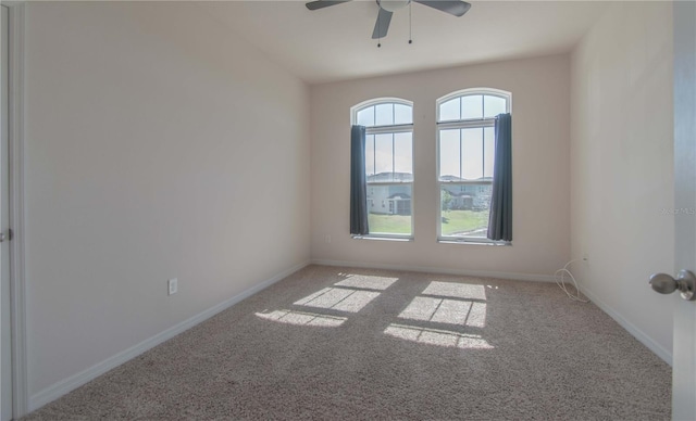 empty room with ceiling fan, plenty of natural light, and carpet