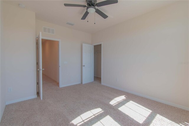 unfurnished bedroom with ceiling fan, carpet flooring, and a closet