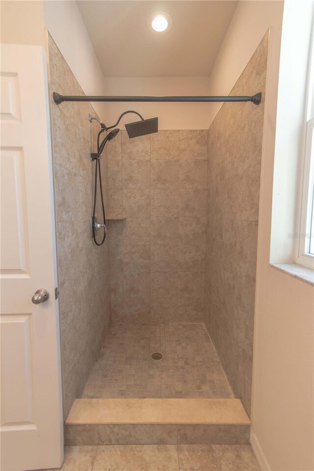 bathroom with tile patterned flooring and tiled shower