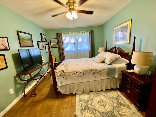 bedroom featuring hardwood / wood-style floors, ceiling fan, and a textured ceiling