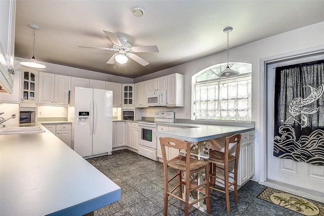 kitchen with ceiling fan, decorative light fixtures, white appliances, and white cabinetry