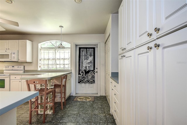 kitchen featuring white appliances, ceiling fan, white cabinetry, and decorative light fixtures