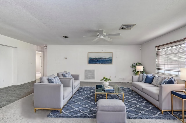 living room with ceiling fan and a textured ceiling