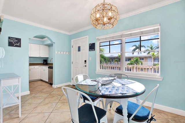 tiled dining space featuring crown molding and an inviting chandelier