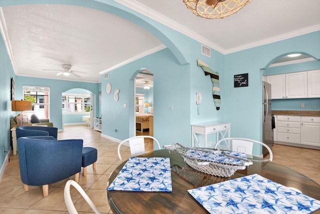 dining space featuring ceiling fan, light tile patterned flooring, and ornamental molding