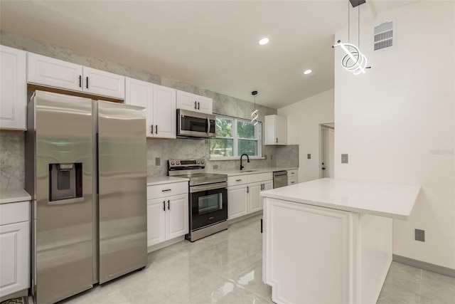 kitchen with white cabinetry, kitchen peninsula, stainless steel appliances, and hanging light fixtures