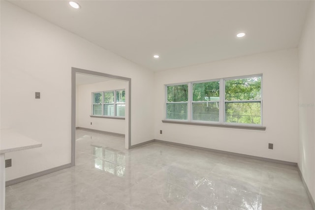 empty room featuring lofted ceiling and a healthy amount of sunlight