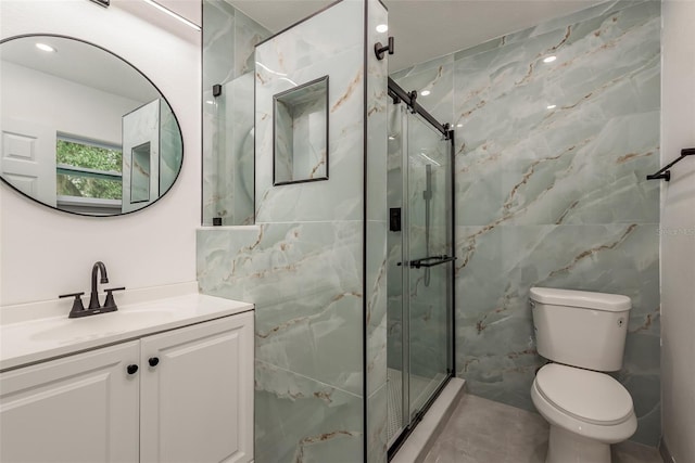 bathroom with tile walls, toilet, a shower with door, and vanity